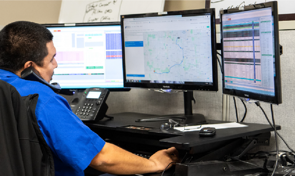 Man on the phone looking at multiple computers